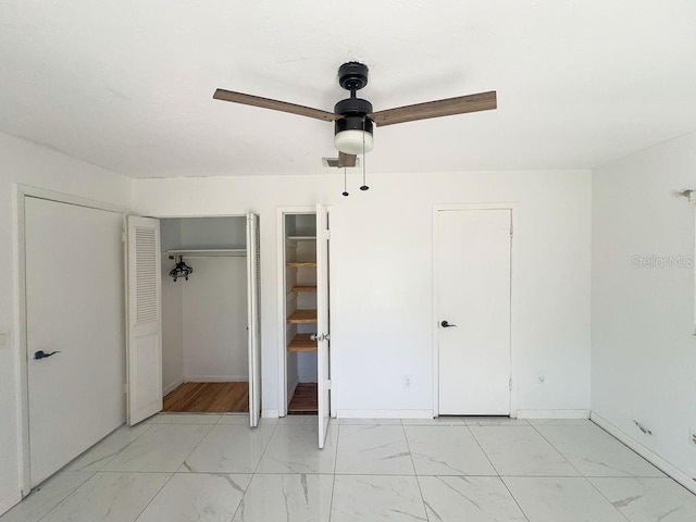 unfurnished bedroom with a ceiling fan, marble finish floor, and baseboards