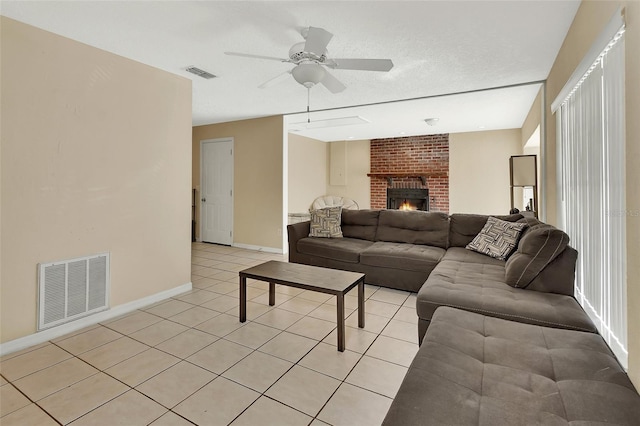 living room featuring light tile patterned floors, a ceiling fan, visible vents, and baseboards