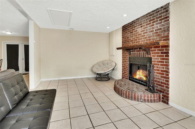 unfurnished living room featuring tile patterned floors, a brick fireplace, baseboards, and a textured ceiling