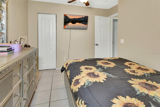 bedroom with light tile patterned floors, a closet, and a ceiling fan