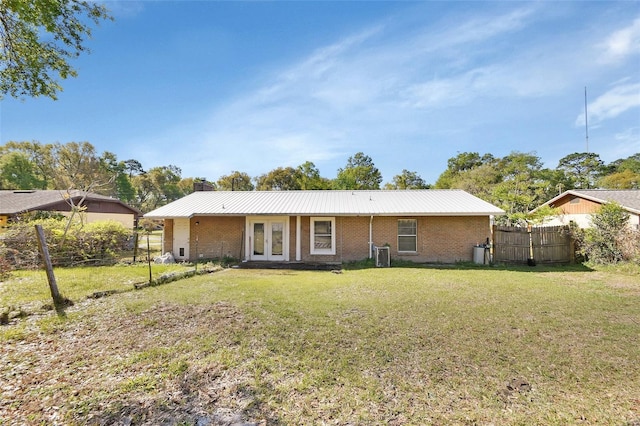 rear view of property with a lawn, fence, french doors, central AC unit, and a chimney