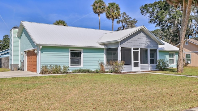 single story home with a chimney, metal roof, a front lawn, and a sunroom