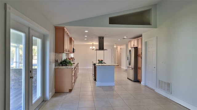 kitchen with visible vents, a center island, appliances with stainless steel finishes, island range hood, and decorative backsplash