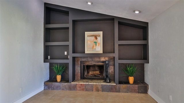 unfurnished living room with built in features, baseboards, a fireplace, and tile patterned floors