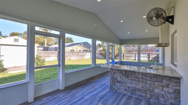 sunroom / solarium featuring vaulted ceiling and a sink