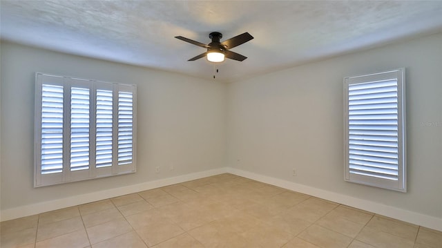 empty room with baseboards and a ceiling fan