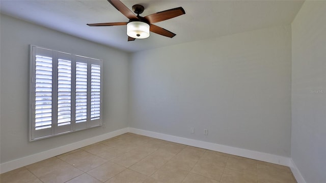 spare room with tile patterned floors, ceiling fan, and baseboards