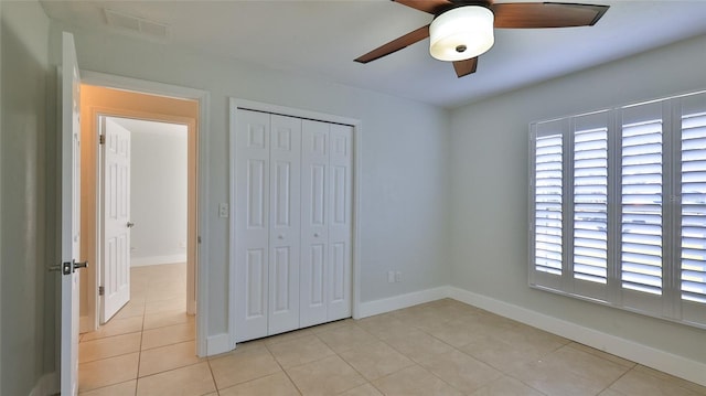 unfurnished bedroom with multiple windows, light tile patterned floors, visible vents, and a closet