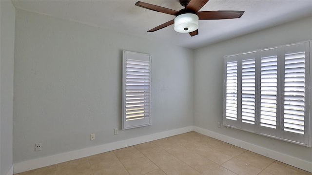 tiled spare room featuring baseboards and ceiling fan