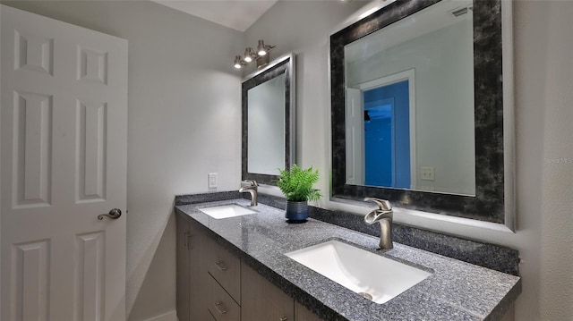 bathroom with double vanity, visible vents, and a sink