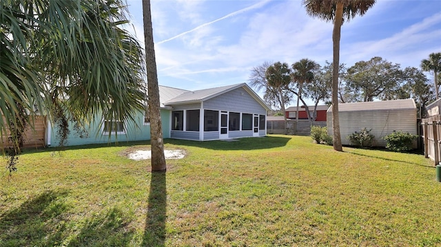 view of yard with an outbuilding, a sunroom, and fence