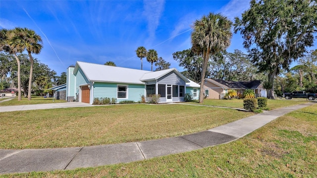 single story home featuring driveway, a front lawn, an attached garage, a sunroom, and a chimney