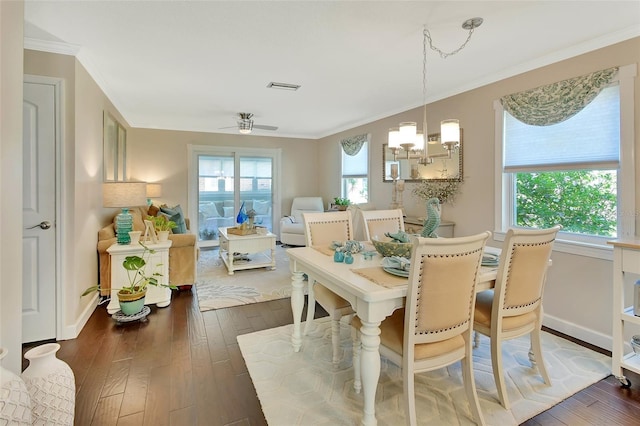 dining area featuring crown molding, visible vents, dark wood-style flooring, and a healthy amount of sunlight