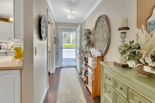 interior space featuring dark wood-style floors, a textured ceiling, crown molding, and baseboards