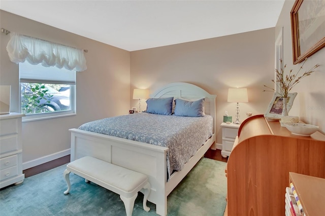 bedroom with baseboards and wood finished floors