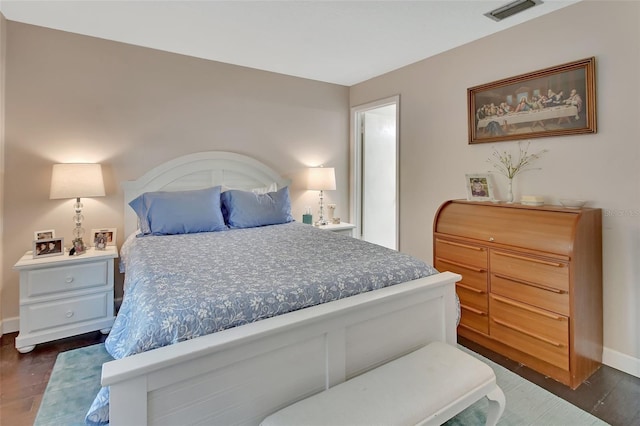 bedroom featuring baseboards, visible vents, and dark wood-style flooring