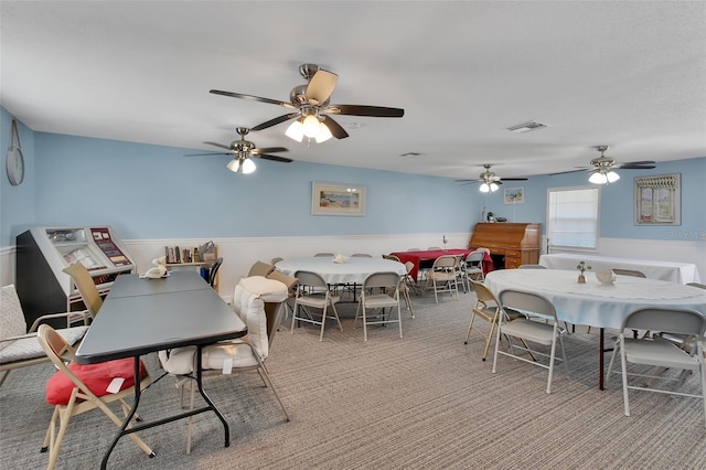 dining room featuring visible vents, carpet flooring, and a wainscoted wall