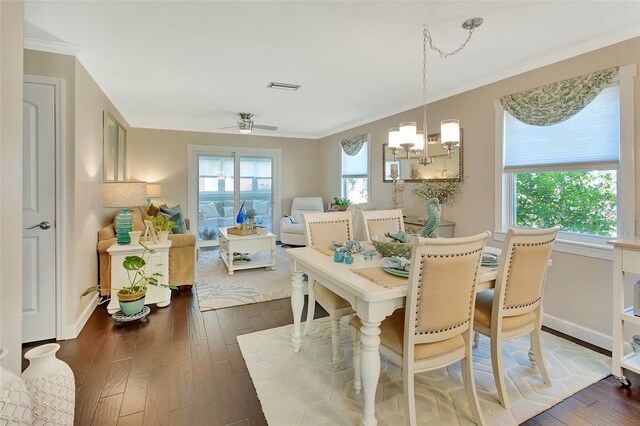 dining room featuring dark wood finished floors, visible vents, crown molding, and baseboards