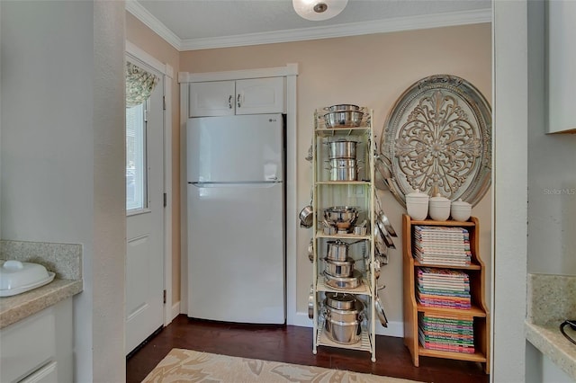 kitchen featuring white cabinets, light countertops, ornamental molding, dark wood-type flooring, and freestanding refrigerator