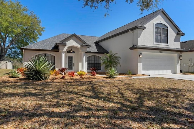 view of front of house featuring stucco siding, an attached garage, and concrete driveway