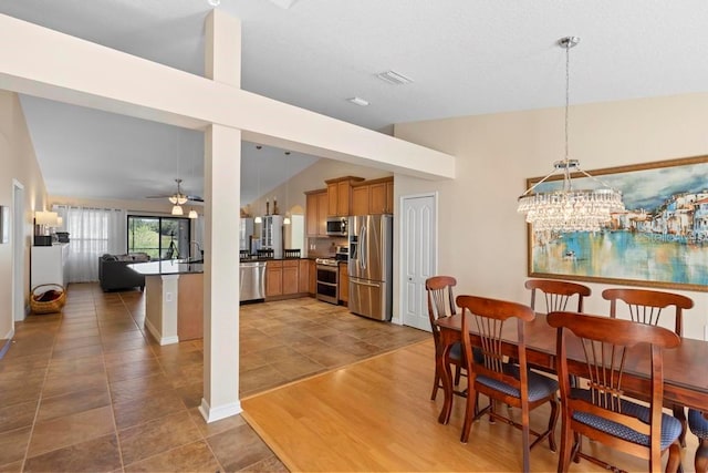 dining room with visible vents, lofted ceiling, ceiling fan, and wood finished floors