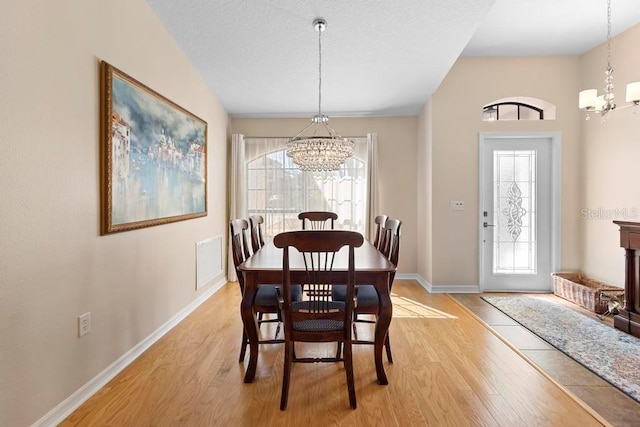 dining room featuring light wood-style floors, a notable chandelier, and visible vents