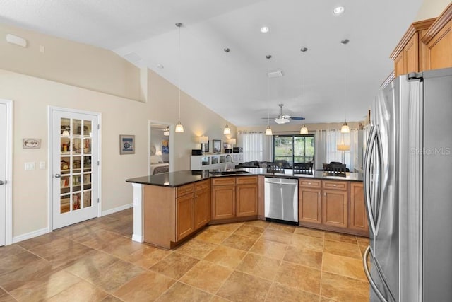 kitchen with dark countertops, stainless steel appliances, brown cabinetry, and a sink