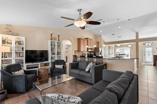 tiled living area with visible vents, vaulted ceiling, recessed lighting, arched walkways, and a ceiling fan