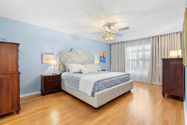 bedroom featuring baseboards, light wood-style floors, ceiling fan, and a textured ceiling