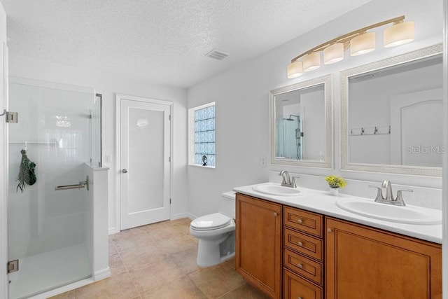 full bathroom with a stall shower, a textured ceiling, and a sink