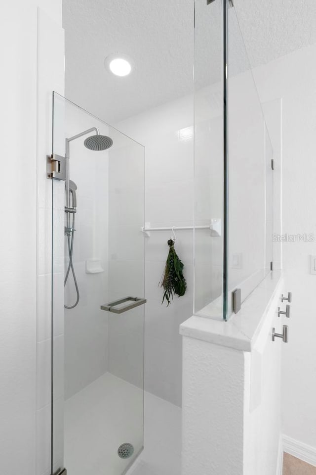 bathroom featuring a textured ceiling and a walk in shower