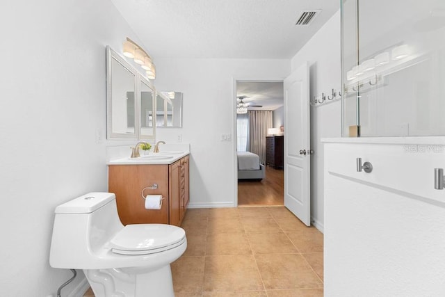 ensuite bathroom with tile patterned floors, visible vents, toilet, baseboards, and vanity