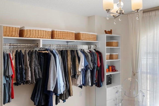 spacious closet featuring a chandelier