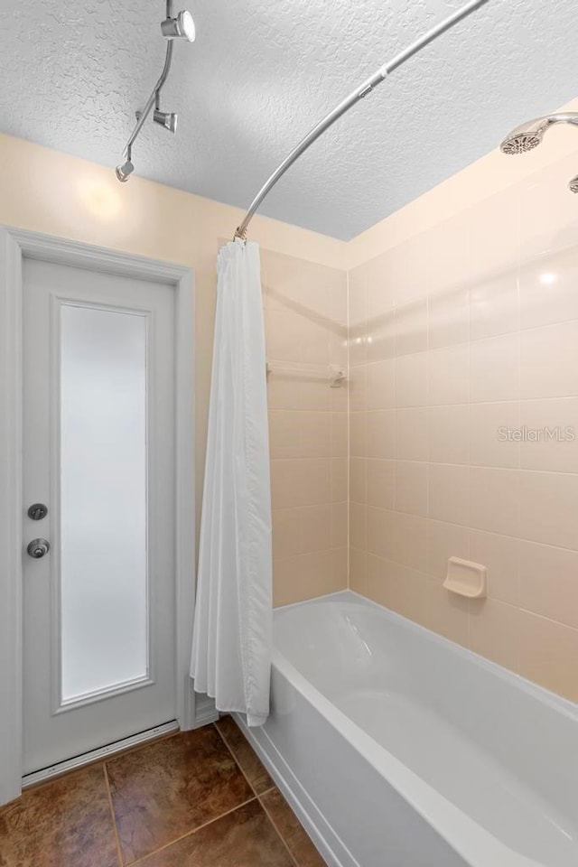 full bathroom featuring tile patterned floors, a textured ceiling, and shower / bathtub combination with curtain