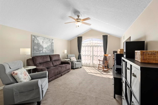 living room with ceiling fan, vaulted ceiling, carpet floors, and a textured ceiling