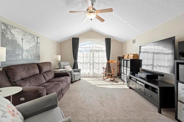 living area with visible vents, vaulted ceiling, carpet flooring, a textured ceiling, and a ceiling fan