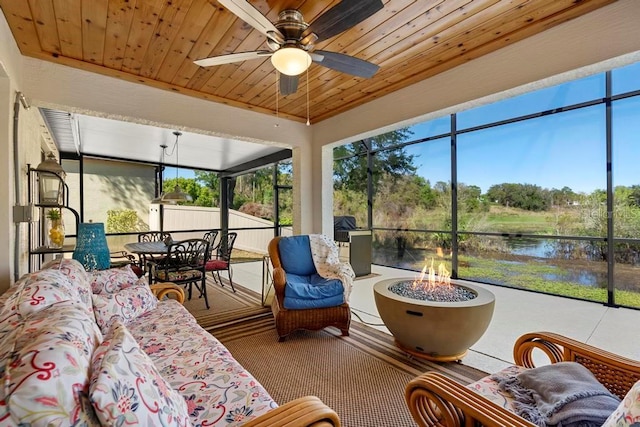 sunroom with wooden ceiling, ceiling fan, and a water view