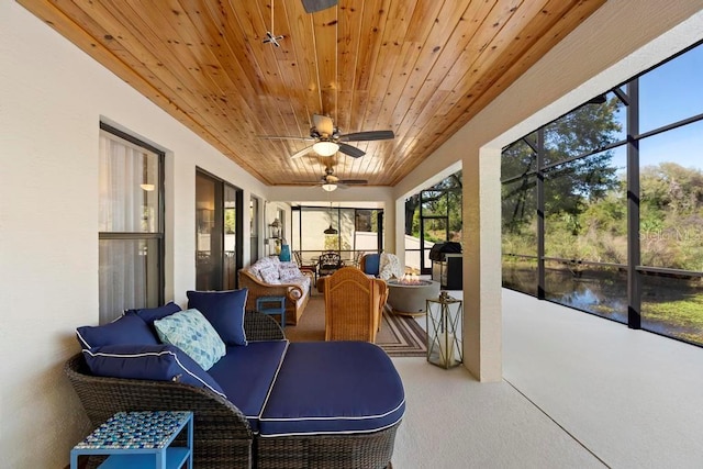 sunroom / solarium featuring a water view, wood ceiling, and ceiling fan