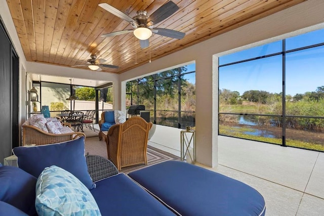 sunroom / solarium with wood ceiling, ceiling fan, and a water view