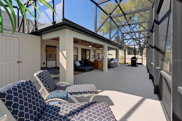 view of patio / terrace with glass enclosure, outdoor dining area, and a ceiling fan