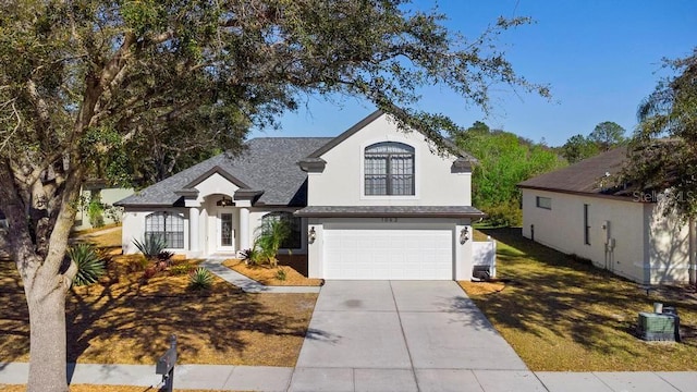 view of front facade featuring stucco siding, concrete driveway, a front lawn, a garage, and central air condition unit