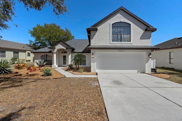 view of front of property with concrete driveway, a garage, and stucco siding