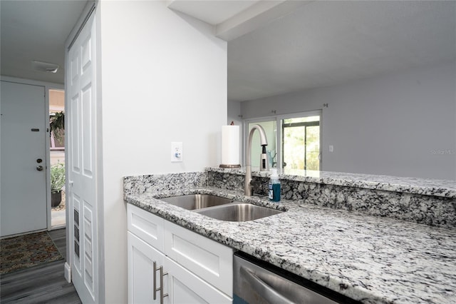 kitchen featuring dark wood-type flooring, dishwasher, light stone counters, white cabinetry, and a sink