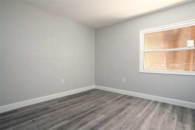 empty room featuring baseboards and wood finished floors