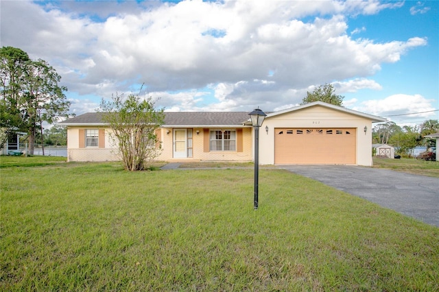 ranch-style home with brick siding, a front lawn, an attached garage, and driveway