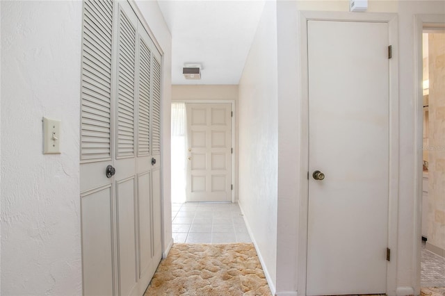 hallway with light tile patterned floors and baseboards