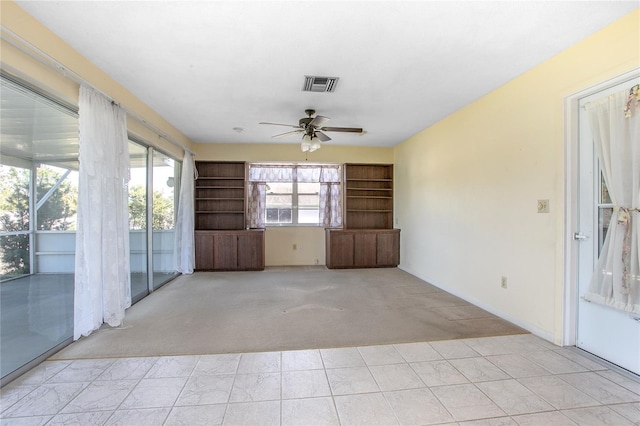 unfurnished sunroom with a ceiling fan and visible vents