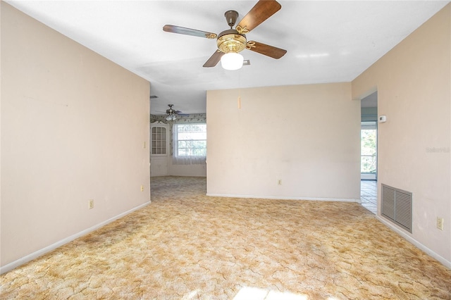 carpeted empty room featuring visible vents, baseboards, and a ceiling fan