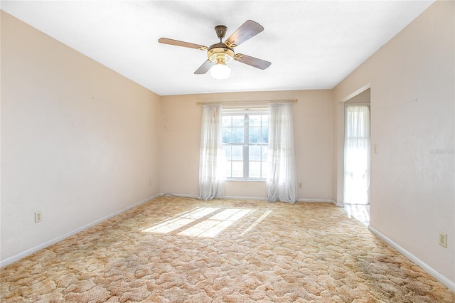 spare room featuring a ceiling fan, baseboards, and carpet floors