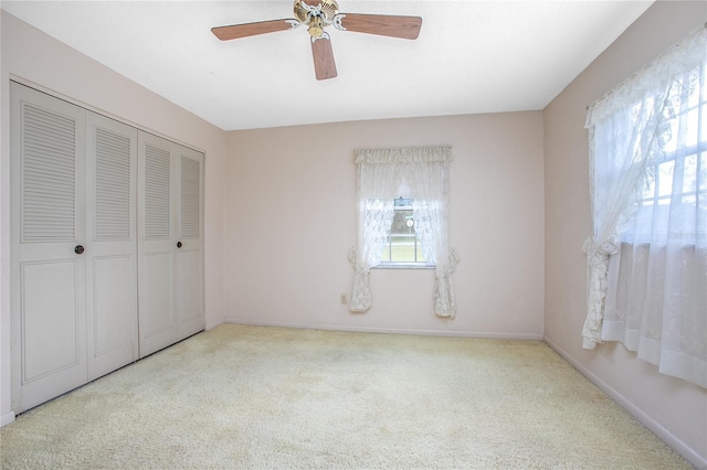 unfurnished bedroom with a closet, carpet flooring, ceiling fan, and baseboards